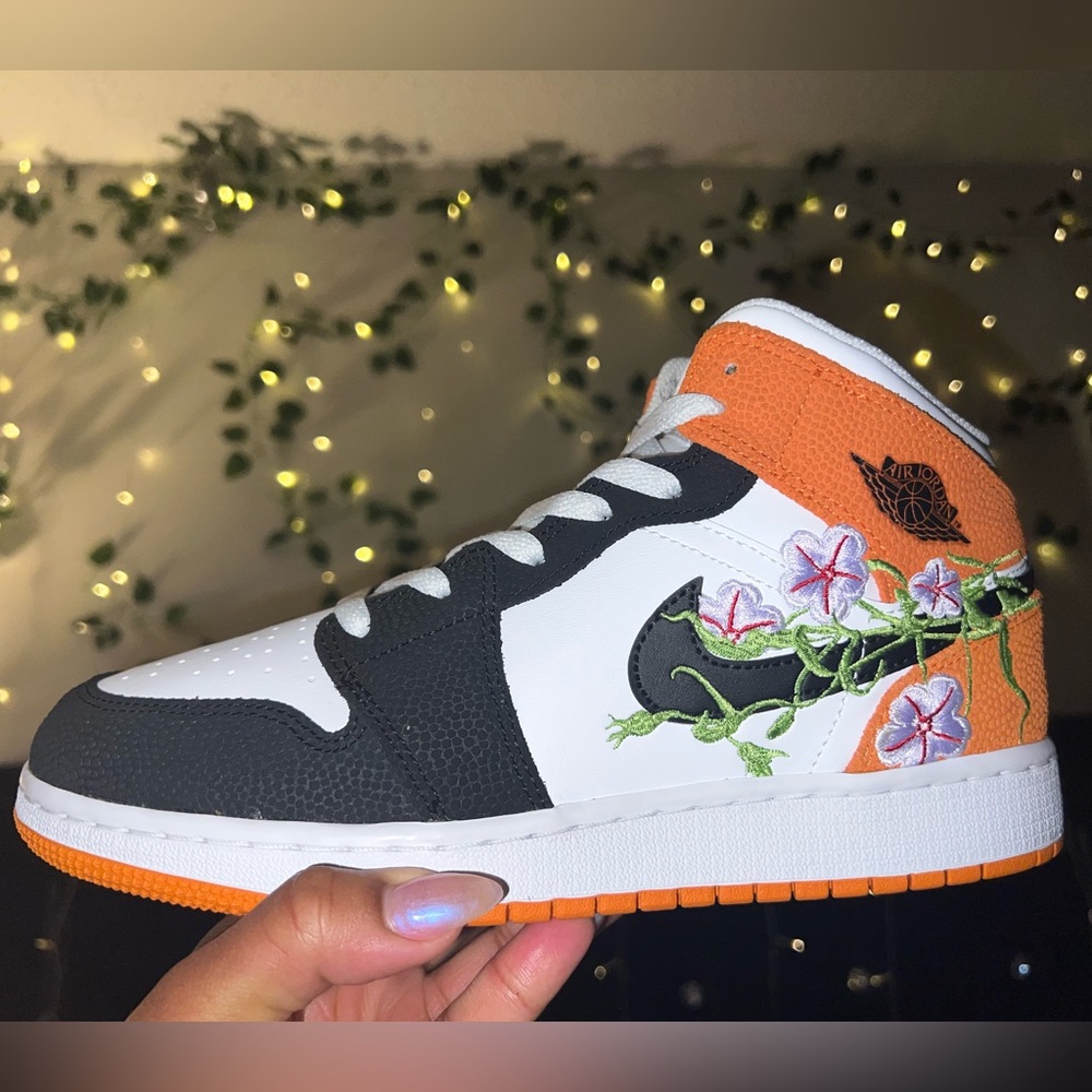 Orange, Black, and White Jordan 1 with Floral Embroidery.